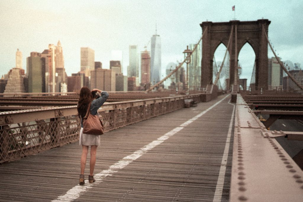 photo of woman on standing on wooden bridge