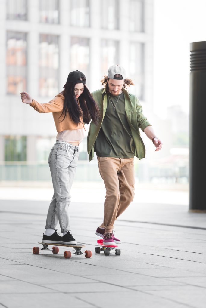 couple skateboarding wearing casual fashion